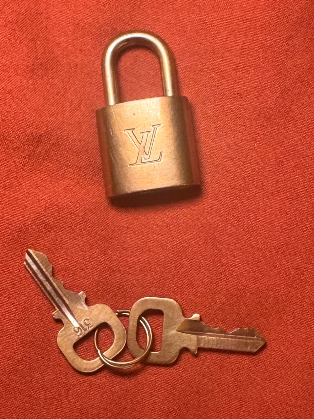 Louis Vuitton Gold Brass Padlock with Keys on Red Background